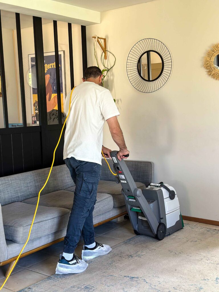 Technicien nettoyant un tapis avec une machine professionnelle