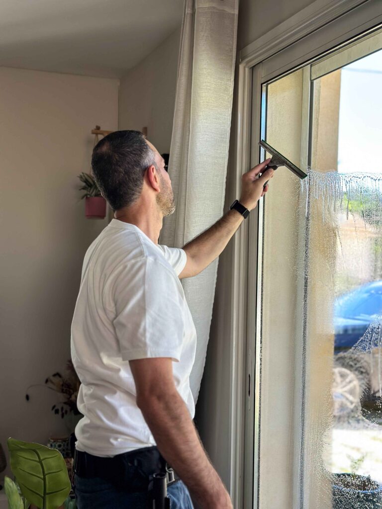 Technicien nettoyant une fenêtre intérieure
